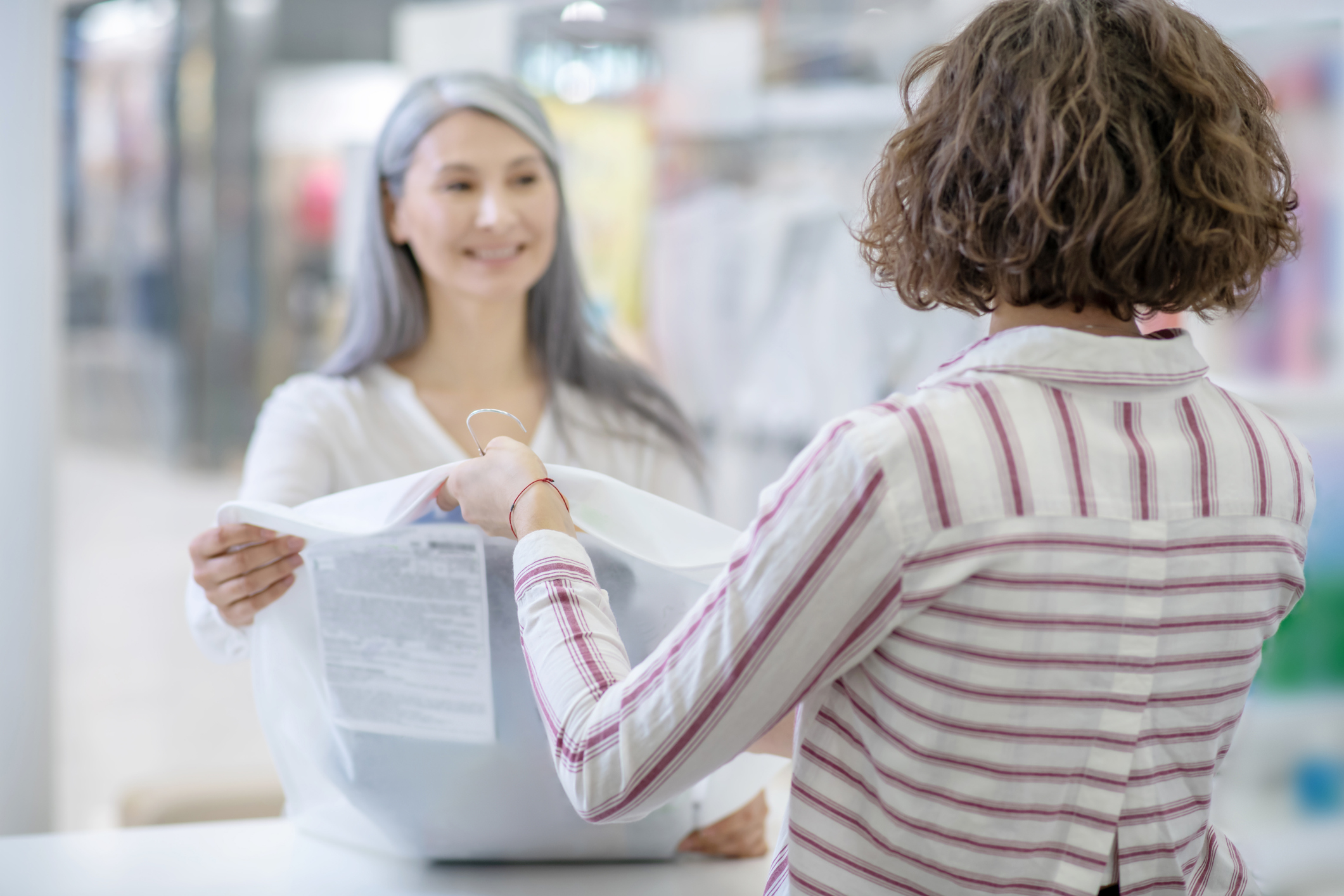 Woman with back to camera giving order to customer Woman with back to camera giving order to customer