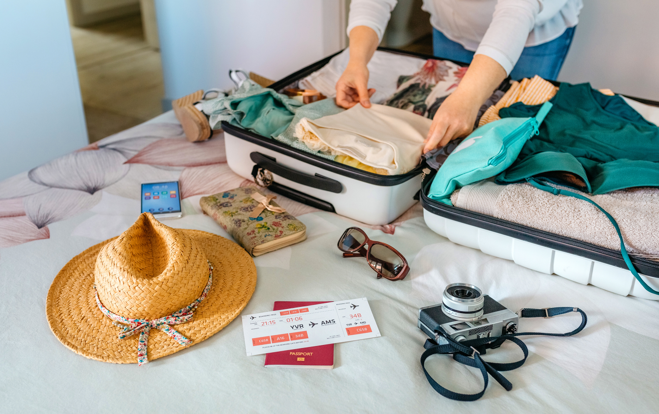 Unrecognizable woman preparing suitcase for summer holidays