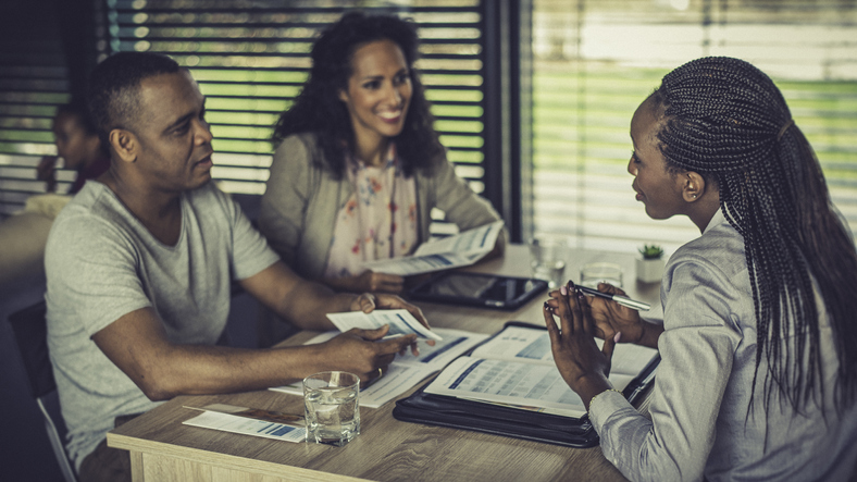 Female financial advisor talking to a couple at home